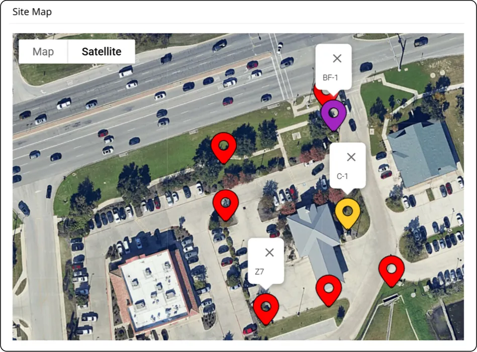 The site map for a property in the app, each backflow, controller and zone dropped as a labelled pin on the satellite view so the next technician can find them.